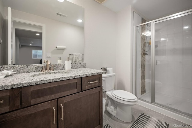 bathroom with visible vents, a stall shower, vanity, tile patterned floors, and toilet