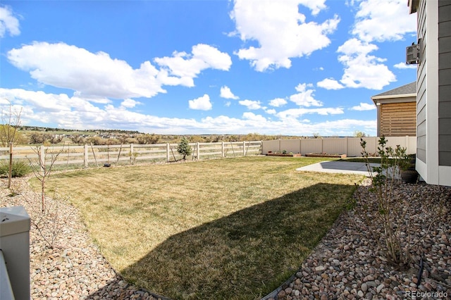view of yard with a patio, a fenced backyard, and a rural view