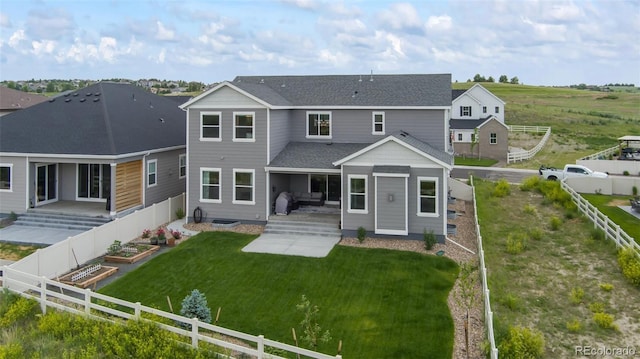 rear view of property with a vegetable garden, a fenced backyard, a yard, a patio, and a shingled roof