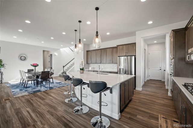 kitchen featuring stainless steel fridge, light countertops, recessed lighting, and dark wood-style flooring