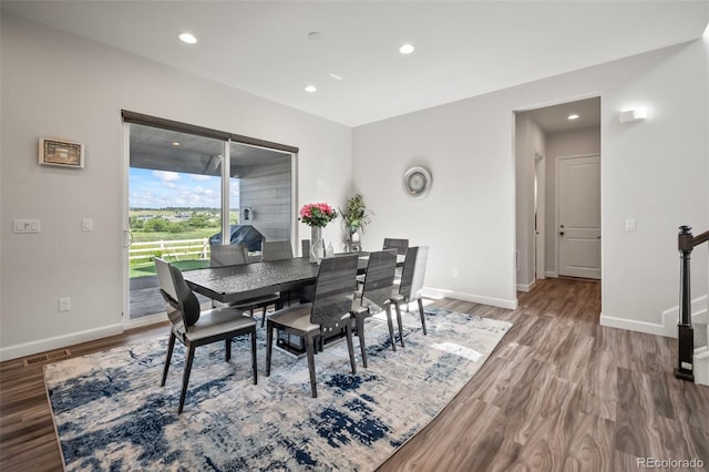 dining area with baseboards, wood finished floors, and visible vents