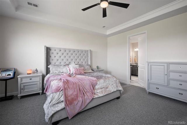 carpeted bedroom featuring a raised ceiling, ornamental molding, ensuite bath, and visible vents