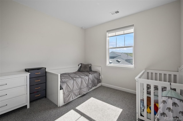 bedroom with baseboards, visible vents, and dark carpet