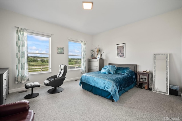 carpeted bedroom featuring baseboards and visible vents
