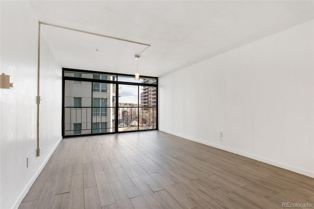 2 Adams St Unit 608, Denver, CO 80206 - spare room with wood finished floors, a wall of windows, and baseboards