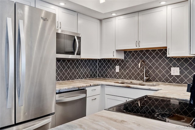 2 Adams St Unit 608, Denver, CO 80206 - kitchen with stainless steel appliances, a sink, white cabinetry, tasteful backsplash, and light stone countertops