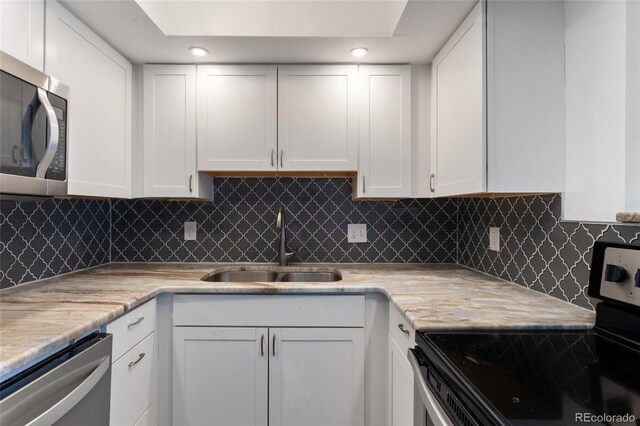 2 Adams St Unit 608, Denver, CO 80206 - kitchen with appliances with stainless steel finishes, a sink, white cabinets, decorative backsplash, and recessed lighting