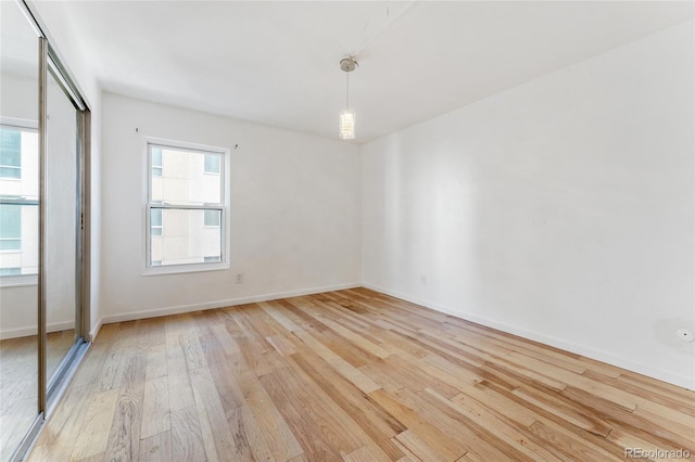2 Adams St Unit 608, Denver, CO 80206 - unfurnished bedroom with light wood finished floors, multiple windows, baseboards, and a closet