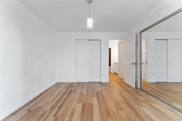 2 Adams St Unit 608, Denver, CO 80206 - unfurnished bedroom featuring light wood-style flooring, multiple closets, and baseboards