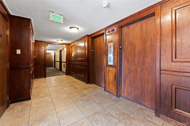 2 Adams St Unit 608, Denver, CO 80206 - corridor featuring a textured ceiling, light tile patterned floors, and wood walls