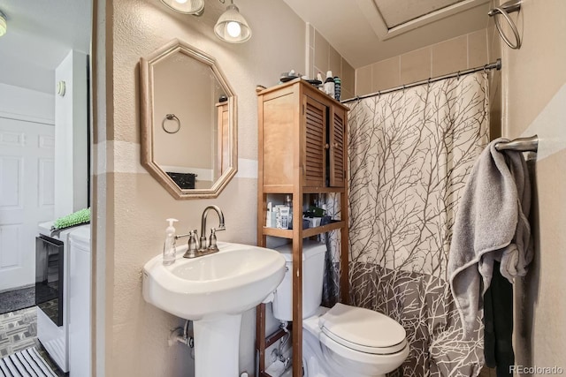 bathroom featuring toilet and curtained shower