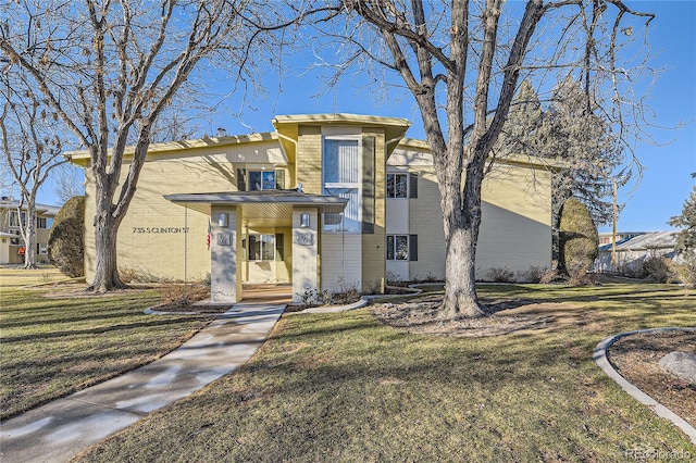 view of front of home with brick siding and a front lawn