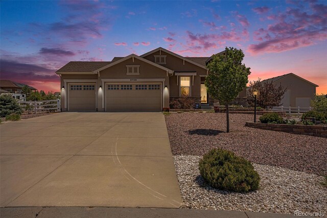 9709 Rockingham Dr, Peyton, CO 80831 - view of front of home with stucco siding, an attached garage, and driveway