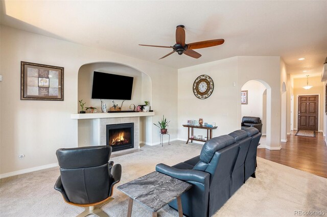 9709 Rockingham Dr, Peyton, CO 80831 - carpeted living area featuring ceiling fan, a fireplace, arched walkways, baseboards, and recessed lighting