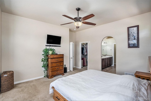 9709 Rockingham Dr, Peyton, CO 80831 - bedroom featuring arched walkways, a walk in closet, light carpet, baseboards, and a closet