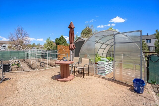 9709 Rockingham Dr, Peyton, CO 80831 - view of play area featuring a greenhouse and an outbuilding