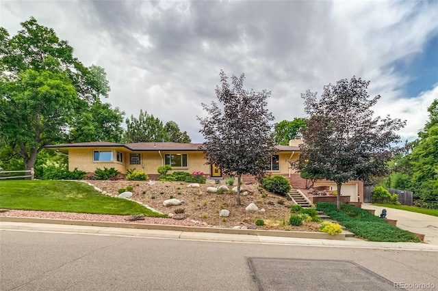 9650 W 35th Ave, Wheat Ridge, CO 80033 - ranch-style home with concrete driveway, brick siding, a garage, and stairway