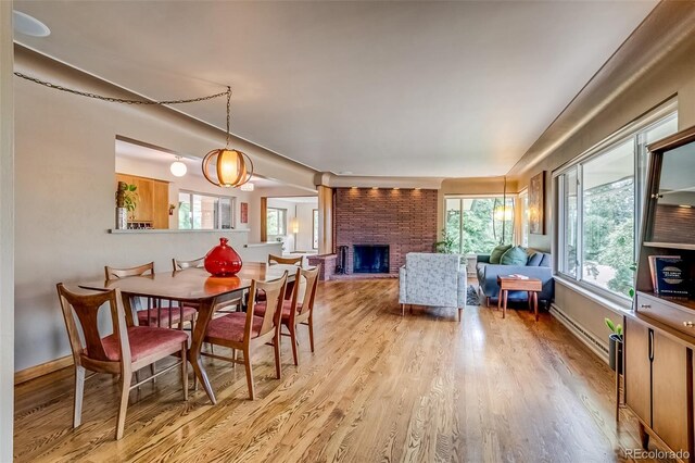 9650 W 35th Ave, Wheat Ridge, CO 80033 - dining space with wood finished floors, a fireplace, and a baseboard heating unit