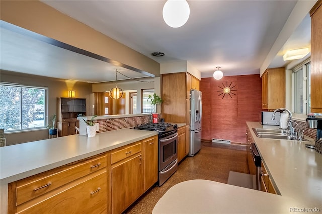 9650 W 35th Ave, Wheat Ridge, CO 80033 - kitchen with stainless steel appliances, light countertops, decorative backsplash, a peninsula, and brown cabinets