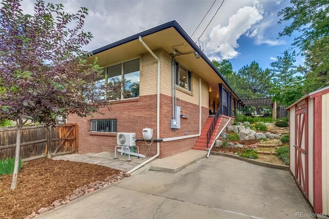 9650 W 35th Ave, Wheat Ridge, CO 80033 - view of property exterior with brick siding, a patio area, and stairway