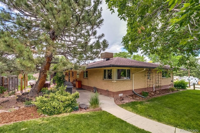 9650 W 35th Ave, Wheat Ridge, CO 80033 - view of side of home with brick siding, a lawn, crawl space, a shingled roof, and a patio