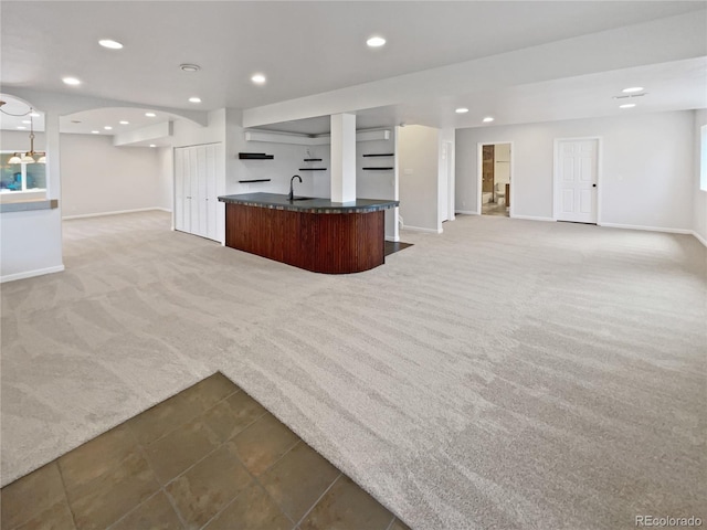 23559 Branston Ln, Parker, CO 80138 - unfurnished living room with light carpet, indoor wet bar, baseboards, recessed lighting, and a sink