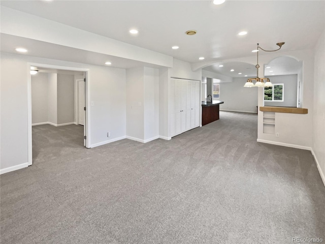 23559 Branston Ln, Parker, CO 80138 - carpeted empty room with baseboards, arched walkways, recessed lighting, and a notable chandelier
