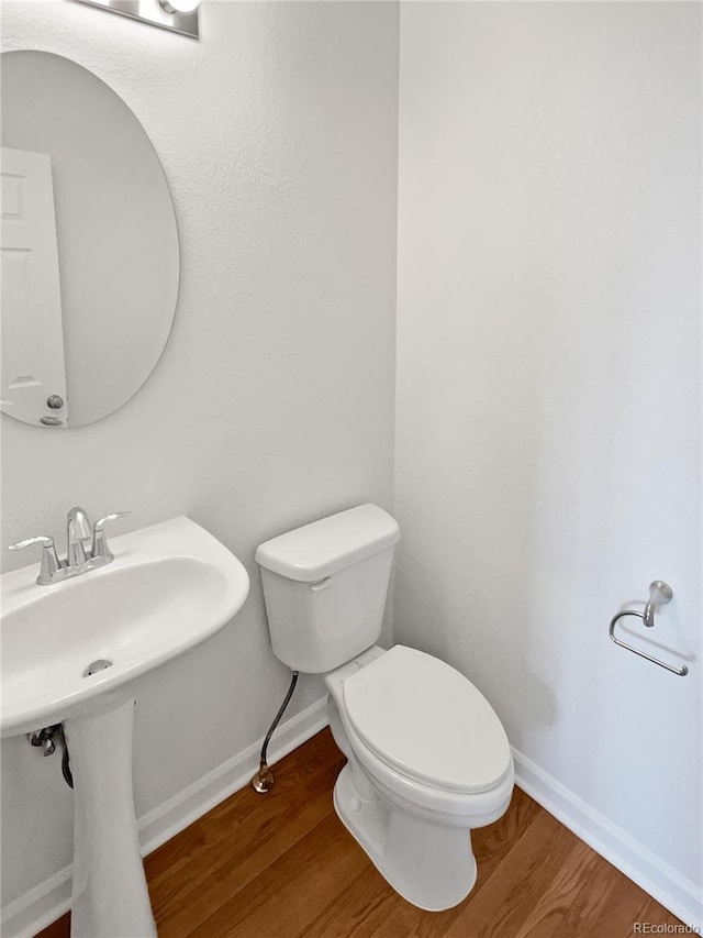 23559 Branston Ln, Parker, CO 80138 - half bath with a sink, baseboards, toilet, and wood finished floors