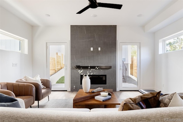 living room with light hardwood / wood-style flooring and ceiling fan