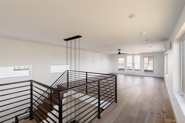 hallway with wood-type flooring and a wall unit AC