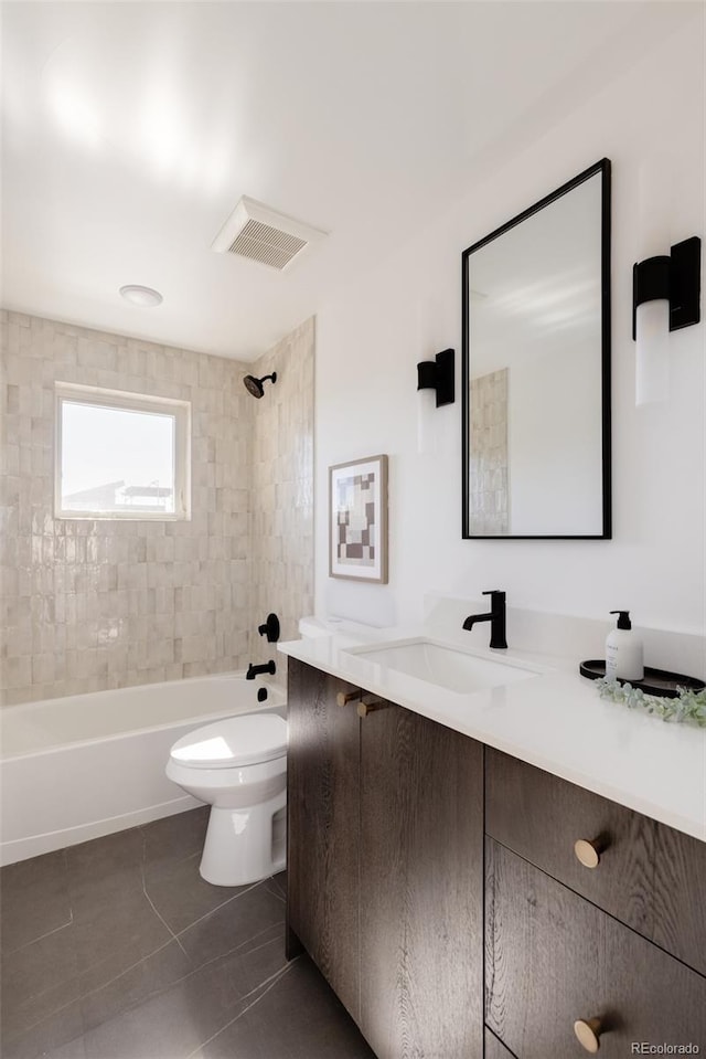 full bathroom featuring toilet, vanity, tile patterned floors, and tiled shower / bath combo