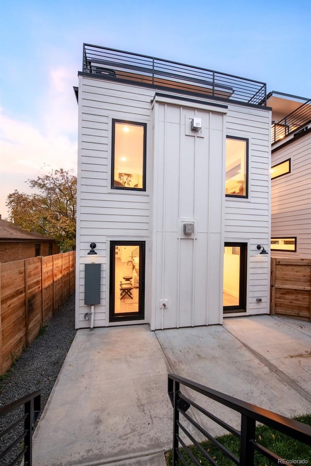 back house at dusk with a patio area