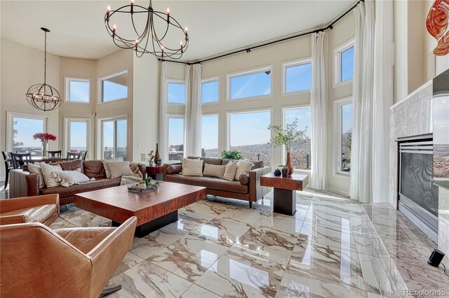 3035 Blodgett Dr, Colorado Springs, CO 80919 - living room featuring marble finish floor, a chandelier, a towering ceiling, and a high end fireplace