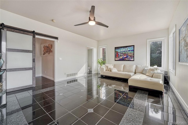 3035 Blodgett Dr, Colorado Springs, CO 80919 - living room with visible vents, baseboards, a ceiling fan, and a barn door
