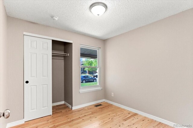 13244 Quivas St, Denver, CO 80234 - unfurnished bedroom featuring light wood-style floors, baseboards, a textured ceiling, and a closet