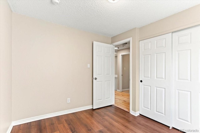 13244 Quivas St, Denver, CO 80234 - unfurnished bedroom featuring baseboards, dark wood-style floors, a closet, and a textured ceiling