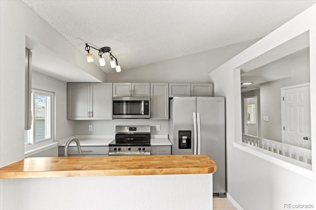 13244 Quivas St, Denver, CO 80234 - kitchen featuring stainless steel appliances, gray cabinetry, butcher block counters, a textured ceiling, and a sink