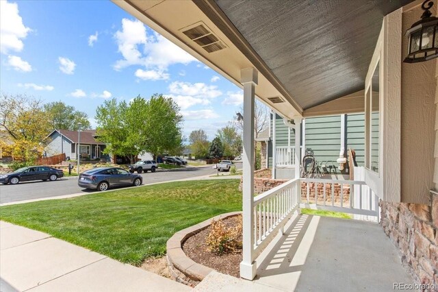 13244 Quivas St, Denver, CO 80234 - covered porch featuring a yard and a residential view