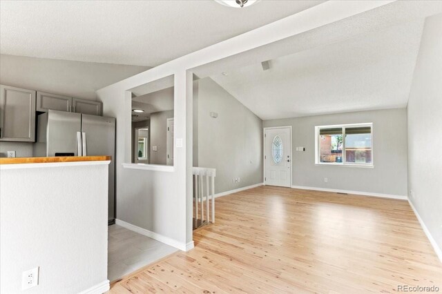 13244 Quivas St, Denver, CO 80234 - unfurnished living room with light wood-type flooring, lofted ceiling, and baseboards