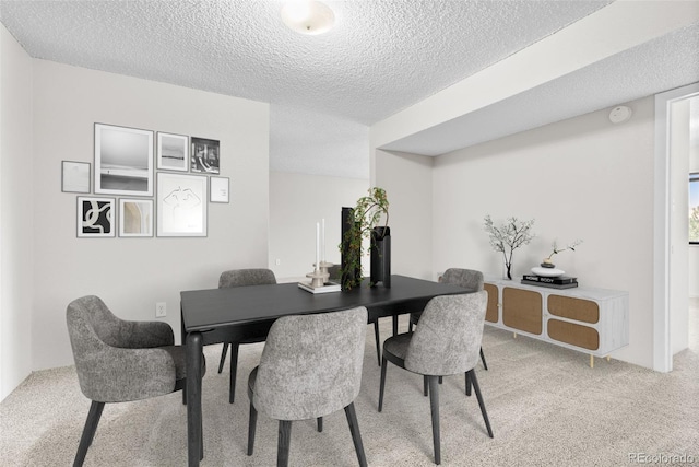 dining area with a textured ceiling and carpet floors