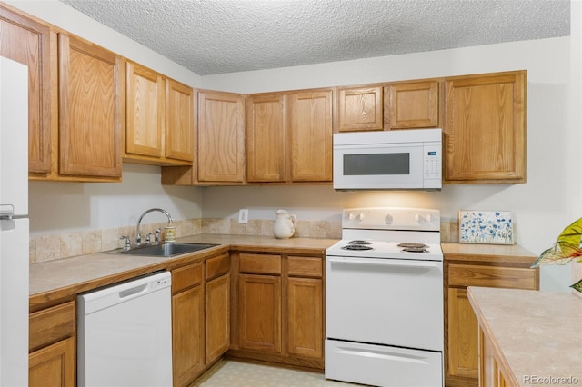 kitchen with a textured ceiling, white appliances, a sink, light countertops, and brown cabinets