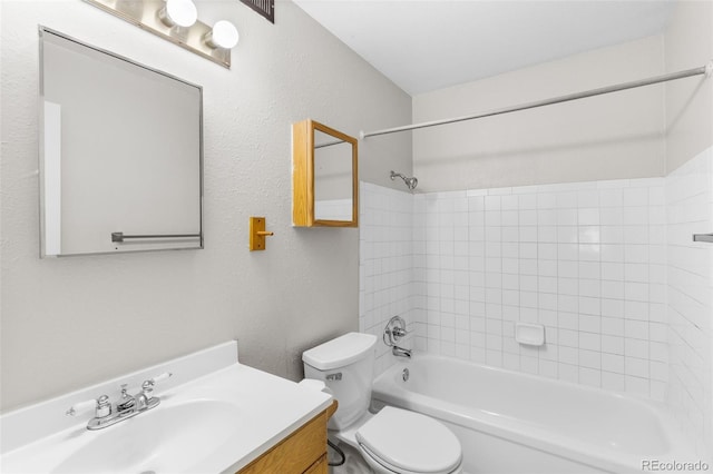 full bath with a textured wall,  shower combination, vanity, and toilet