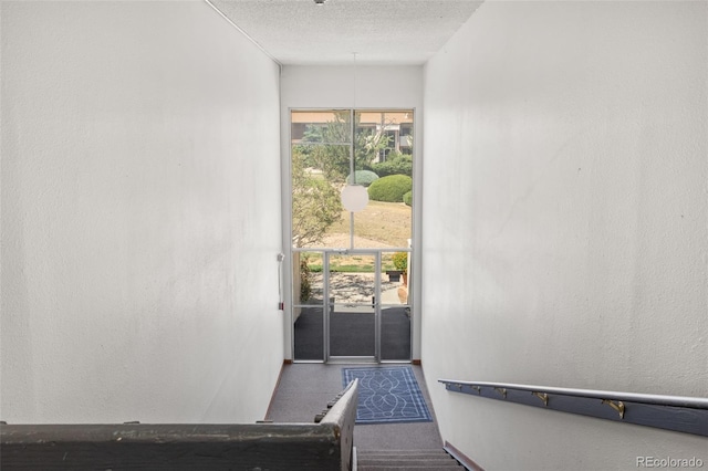 stairway with a textured ceiling