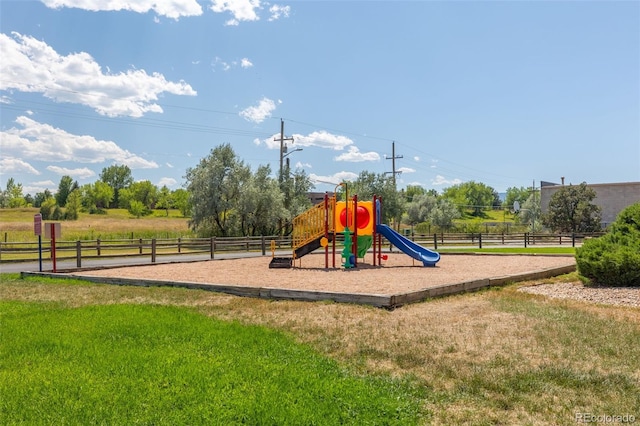 community jungle gym featuring a yard and fence