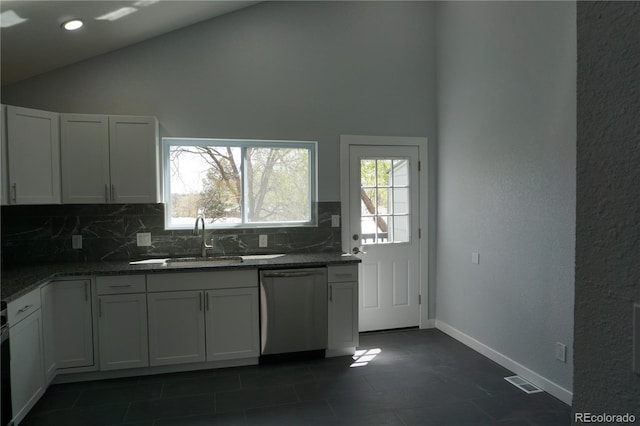 kitchen featuring dishwasher, a sink, decorative backsplash, plenty of natural light, and high vaulted ceiling