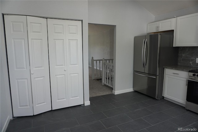 kitchen with stainless steel appliances, white cabinetry, tasteful backsplash, baseboards, and dark tile patterned flooring