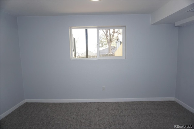 carpeted spare room featuring baseboards
