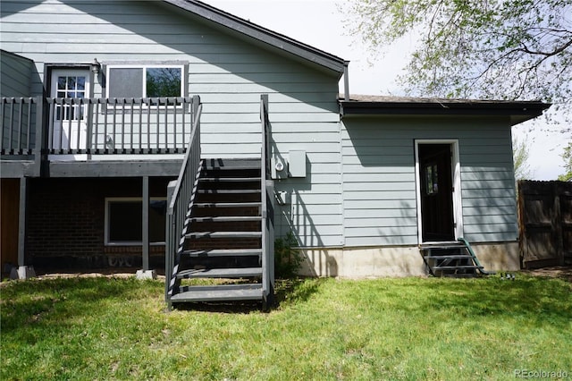 back of house with entry steps, stairs, a yard, and a deck
