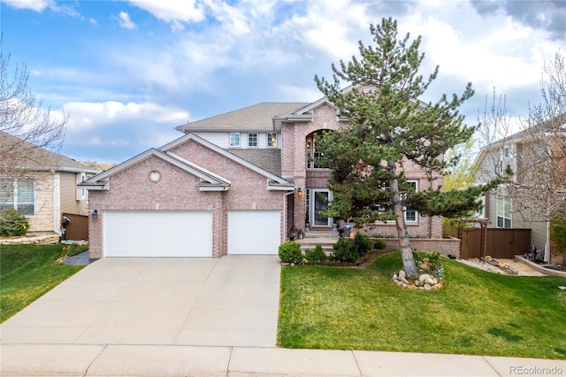 traditional-style house with a front yard, brick siding, fence, concrete driveway, and an attached garage