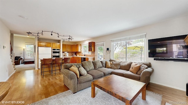 living area with light wood-type flooring and baseboards